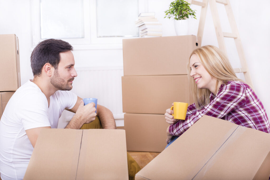 Shared ownership success story - couple sitting with packing boxes