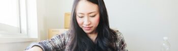 A young Japanese woman is unpacking her things in her new house.