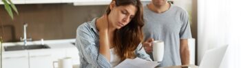 Young couple looking at paperwork with worried expressions