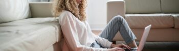 Young woman working on laptop looking thoughtful