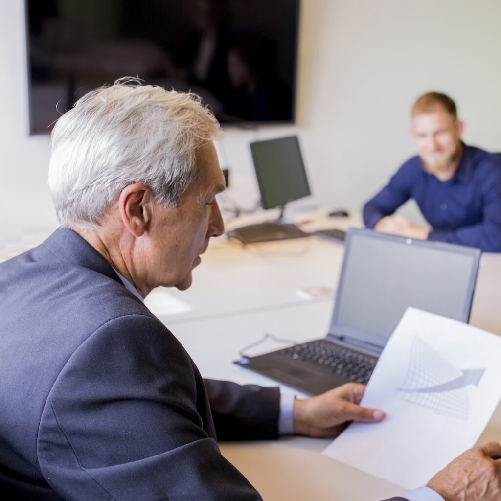 Professional man in an office looking at an upwards graph
