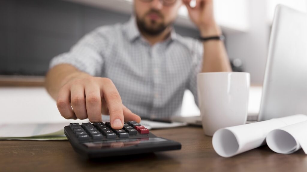 Close up of a man using a calculator