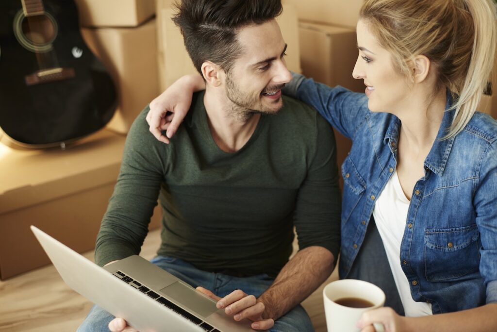 Young couple drinking coffee and working on a laptop
